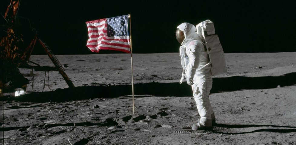 Apollo 11, an astronaut next to an American flag on the moon.