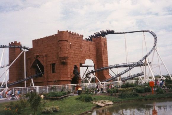 The Tower of Terror, Camelot Theme Park, circa 1990s; a steel rollercoaster track dips in and out of a fibreglass castle structure.