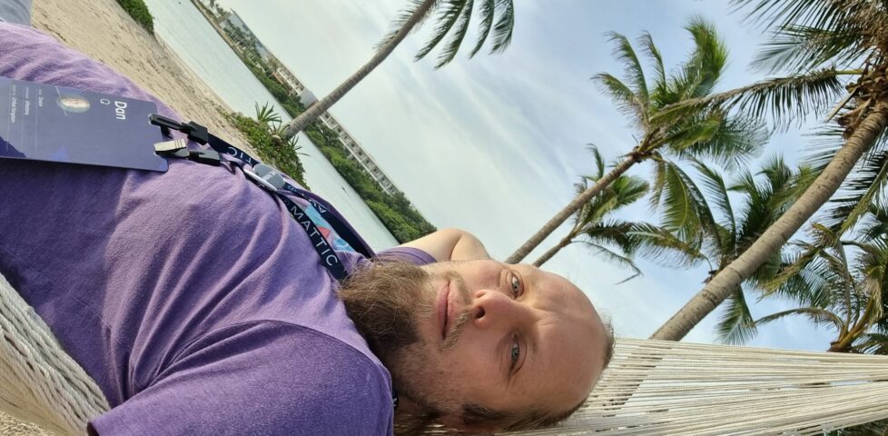 Dan lies in a hammock under a warm sun, smiling.