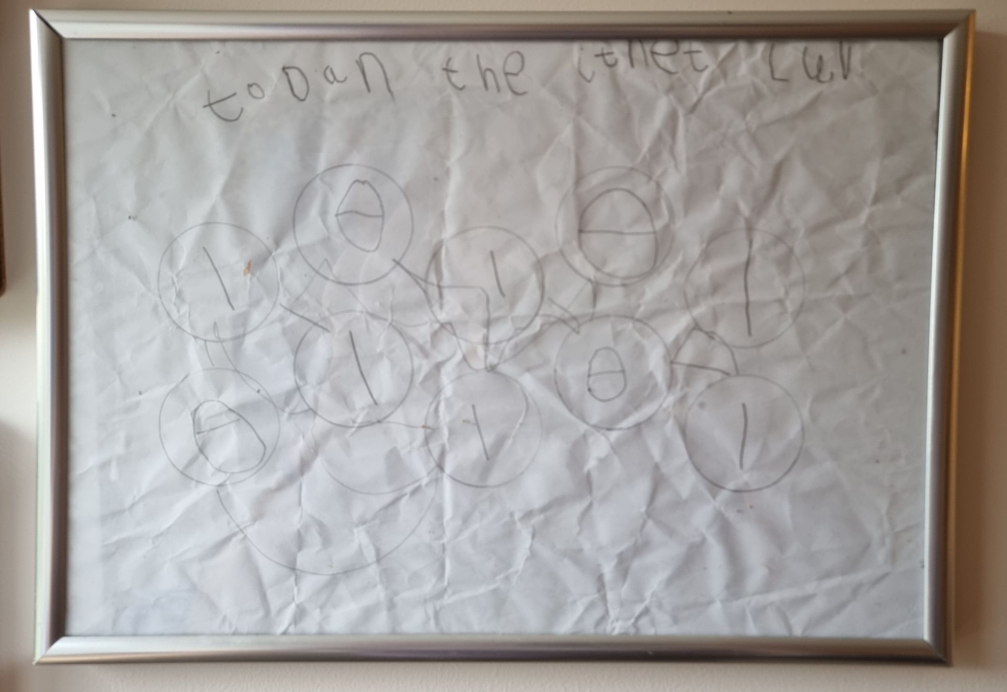 Full image of Framed child-drawn picture showing multiple circles, connected by lines, each with a number 0 or 1 in it.