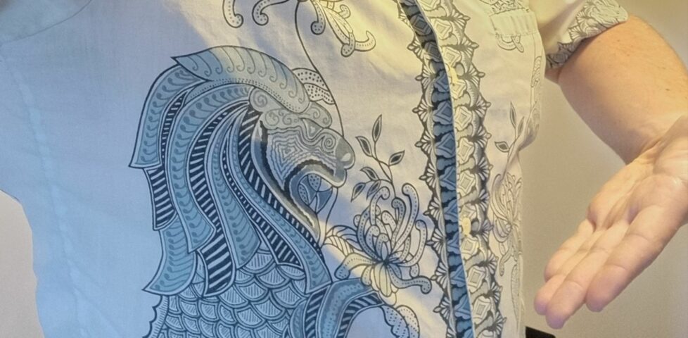 Close-up of an off-white shirt, showing intricate ink patterns reminiscent of a dragon.