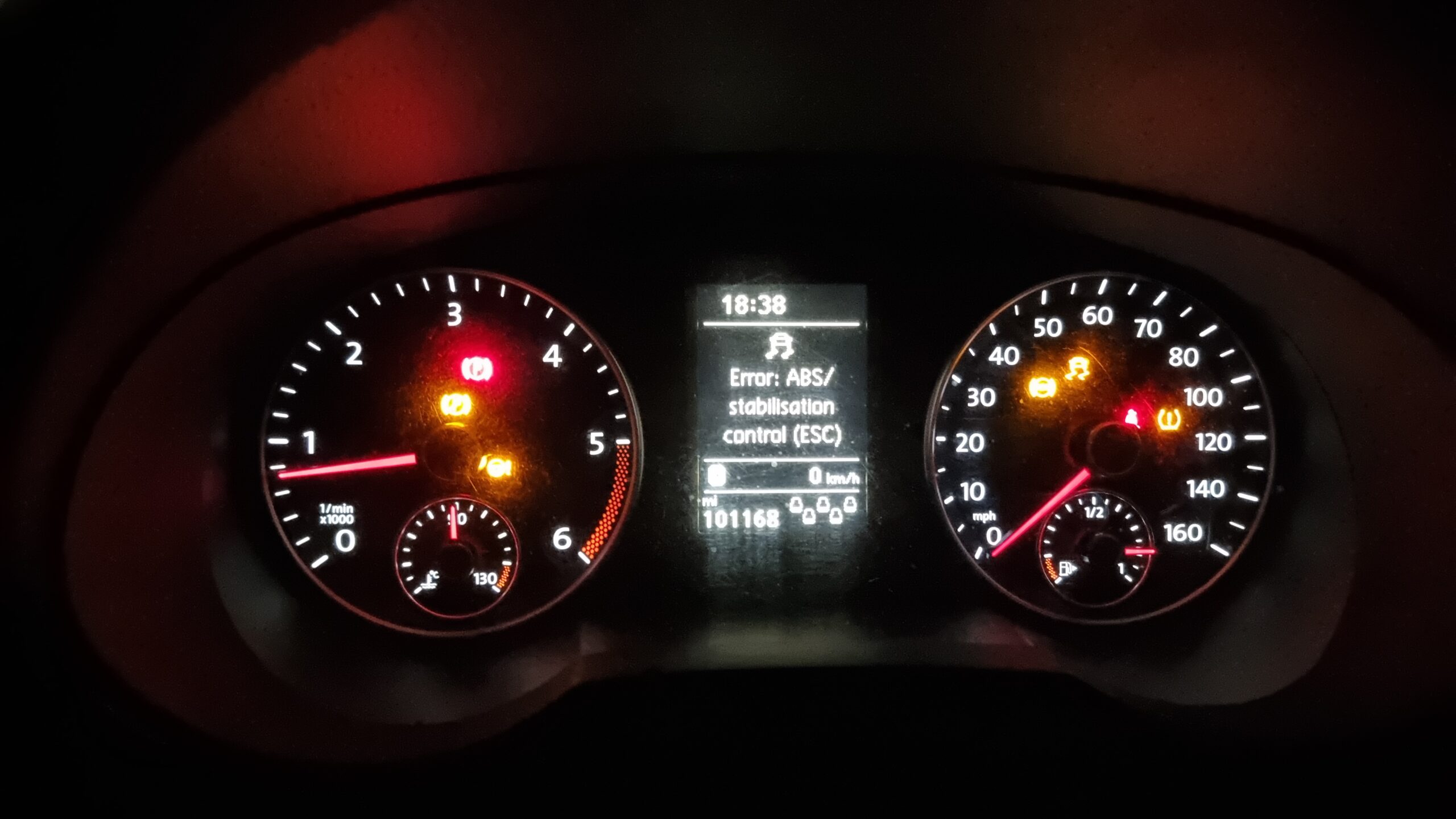 Full image of Car dashboard with seven different warning lights on, plus a message advising that ABS and ESC are not working.