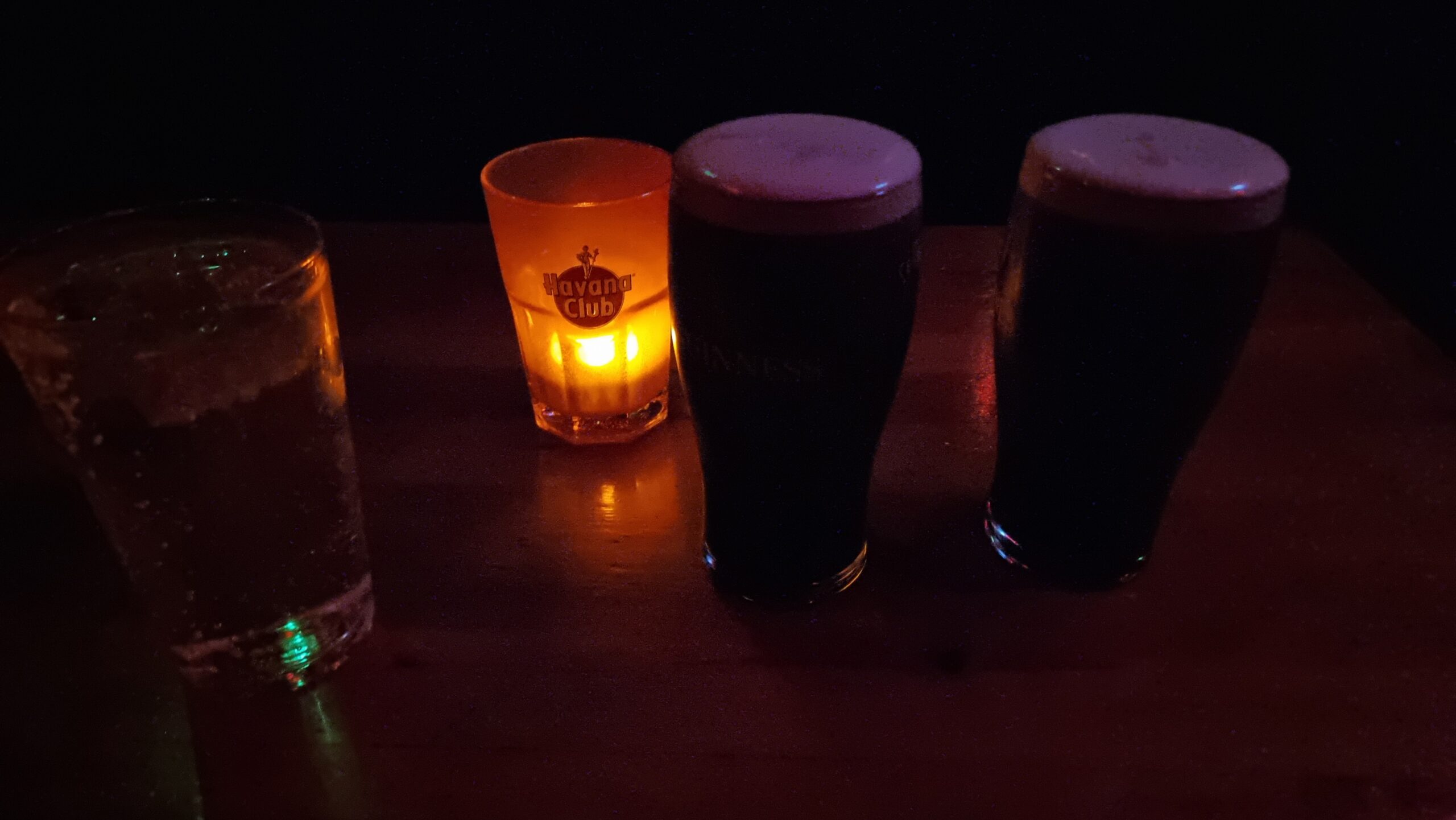 Full image of Two pints of Guinness on a candlelit table.