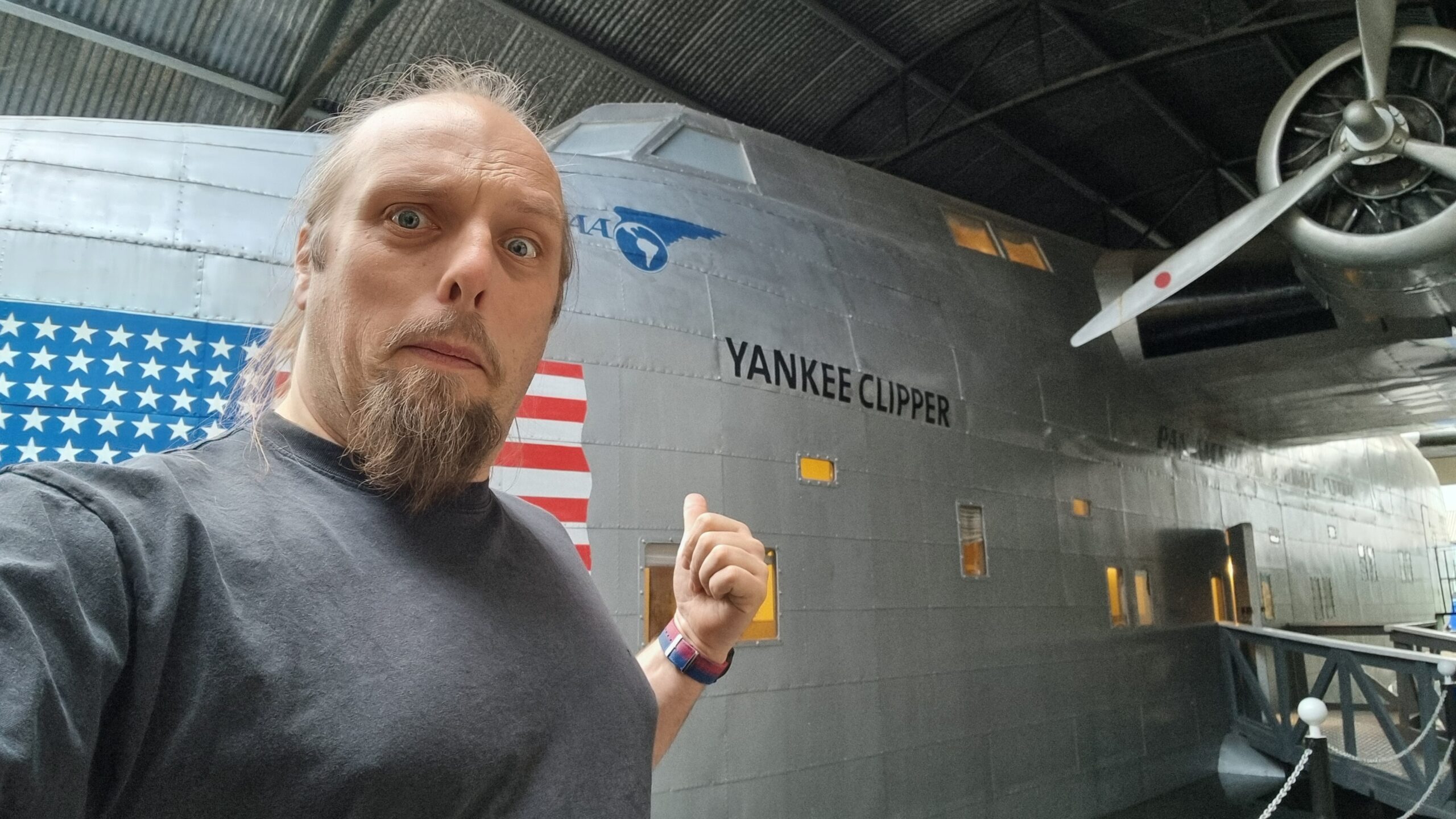 Full image of Dan alongside a replica of a flying boat called Yankee Clipper.