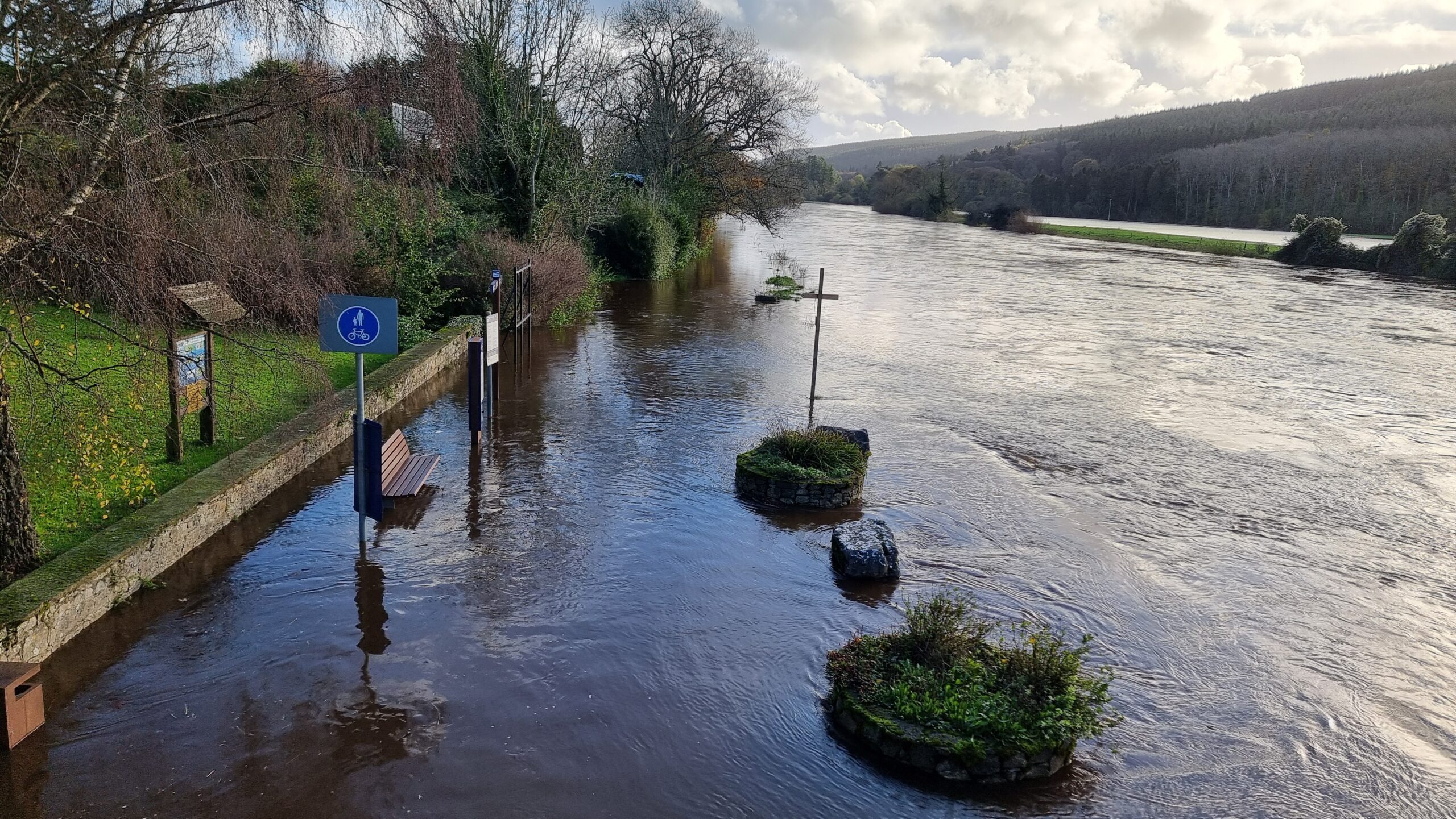 Full image of A riverside footpath is completely flooded.