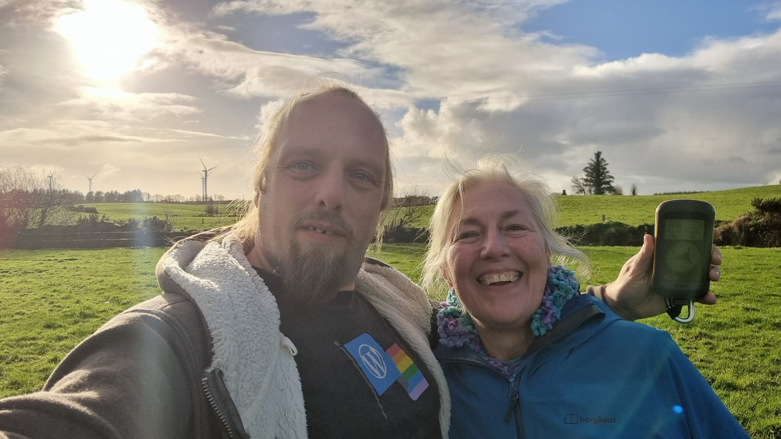 Full image of Dan and his mother grin in a grassy field.