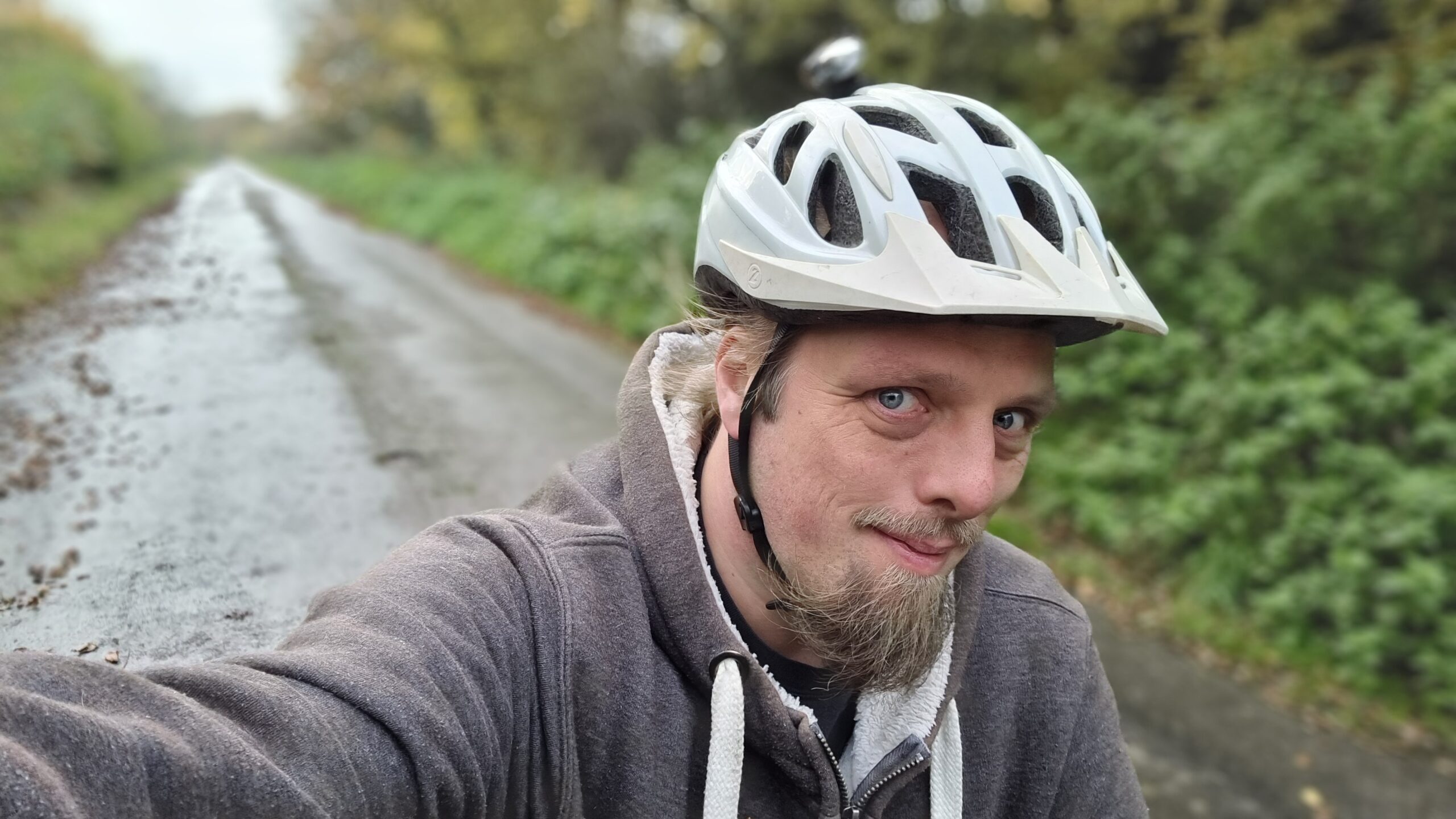 Full image of Dan setting off cycling along a country road.