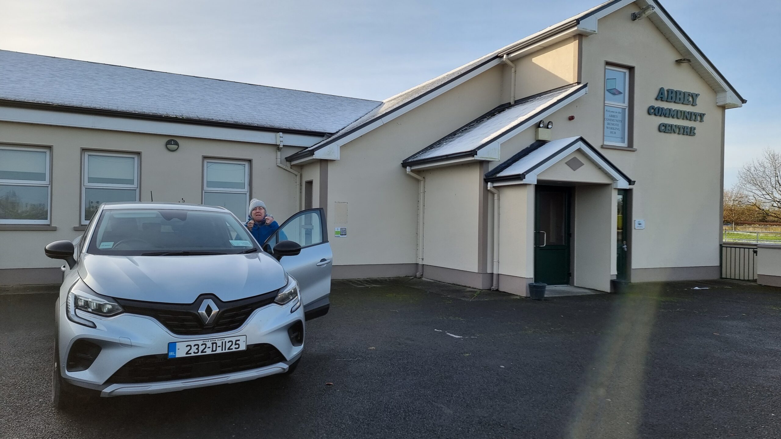 Full image of Abbey Community Centre, plus a car.