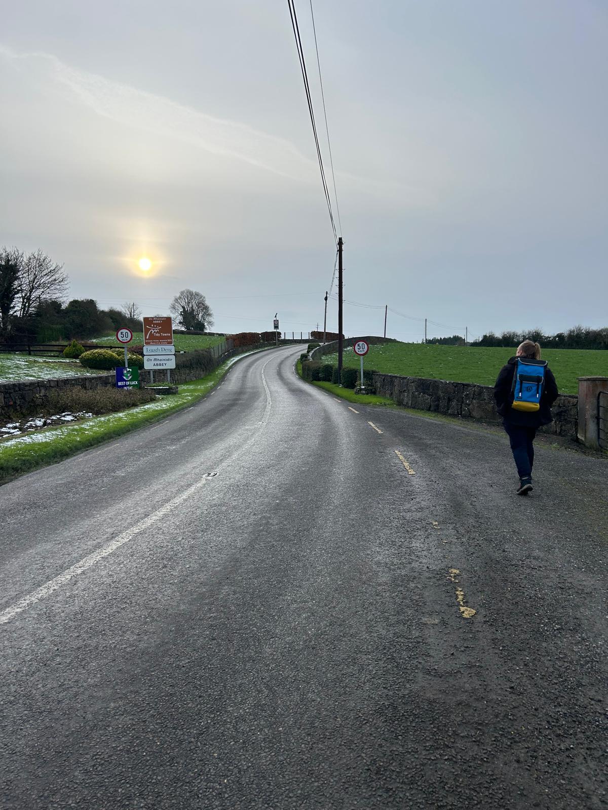 Full image of Dan walking down a road.