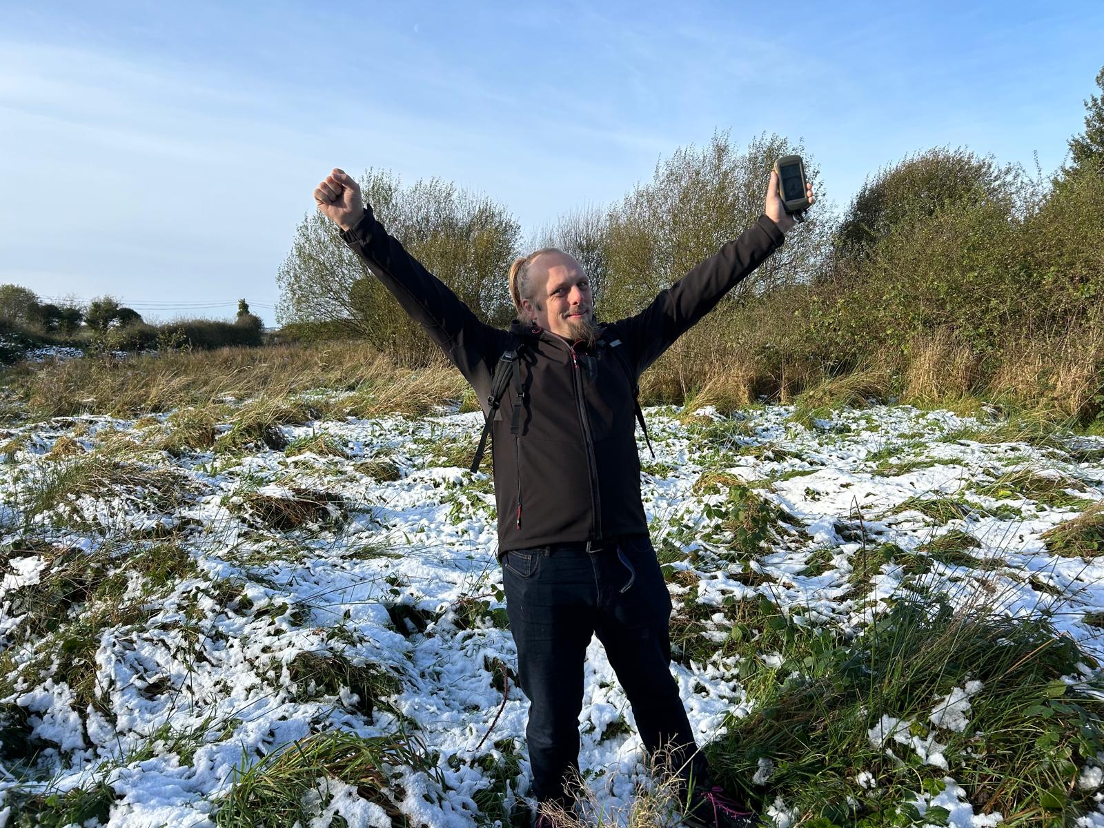 Full image of Dan raises his arms in victory.