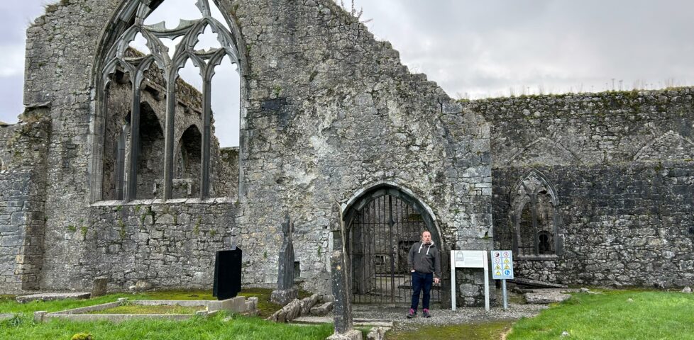 Dan stands in front of a ruined priory.