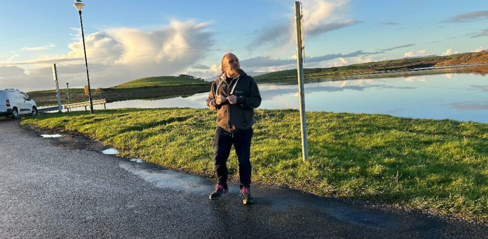 Dan stands near the sea.