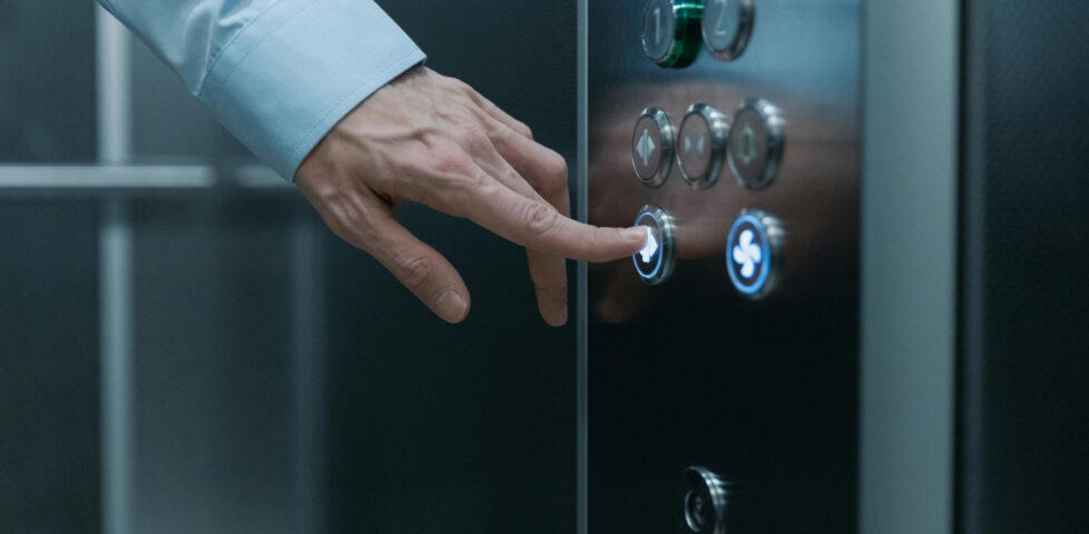 Finger pressing a lift button.