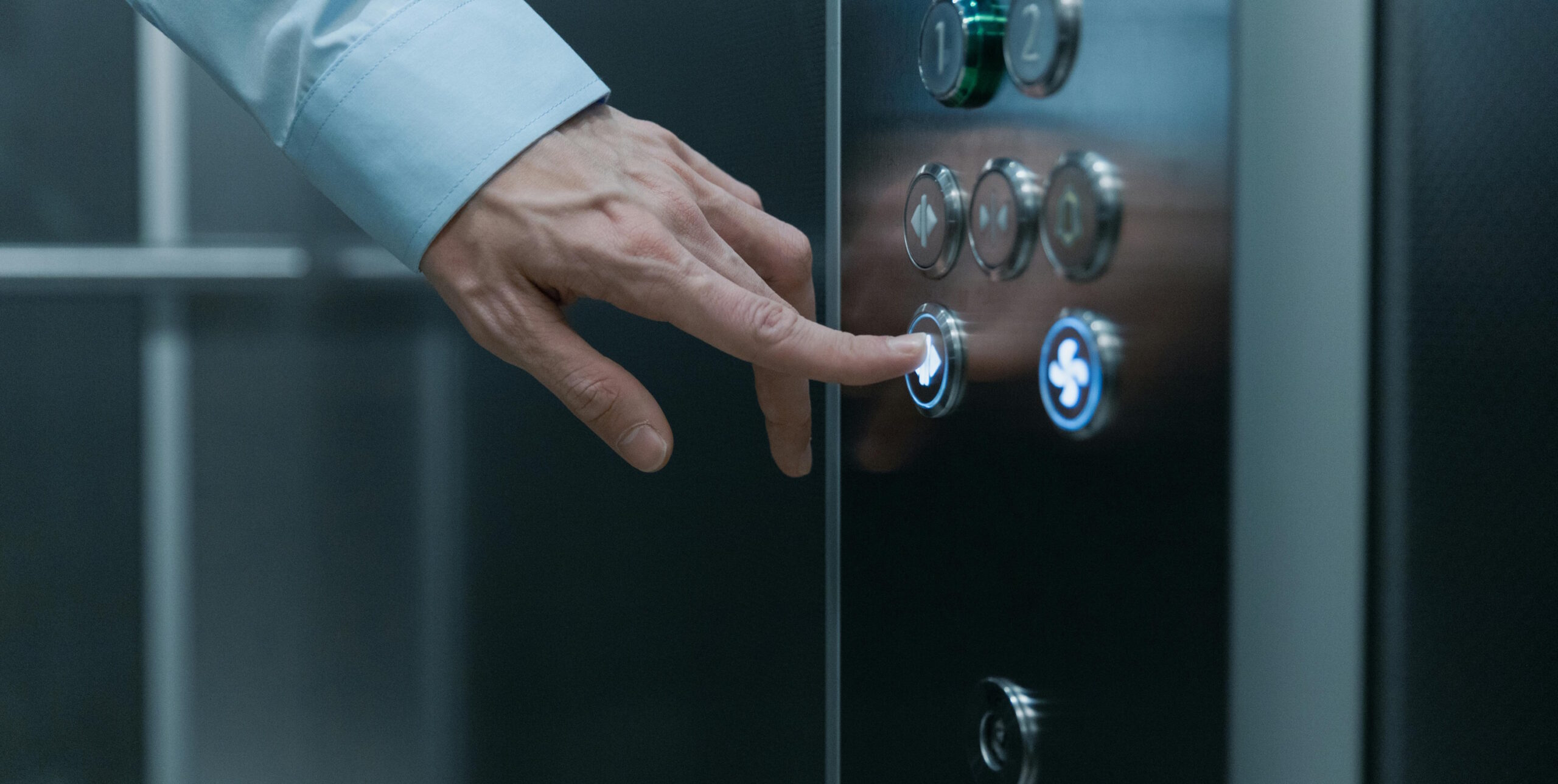 Full image of Finger pressing a lift button.