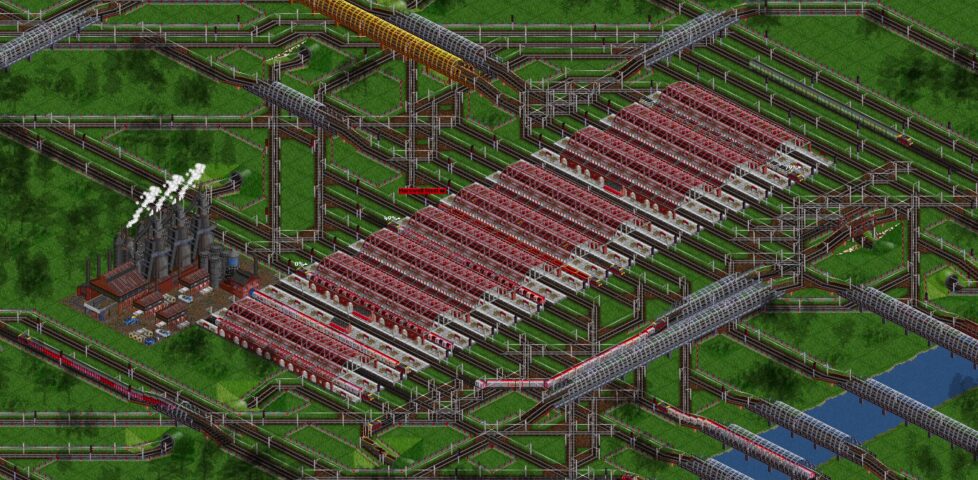Screenshot from OpenTTD, showing a 21-platform station serving a steel mill. 7 platforms are actively being used, while 5 other trains are on approach or exit routes.