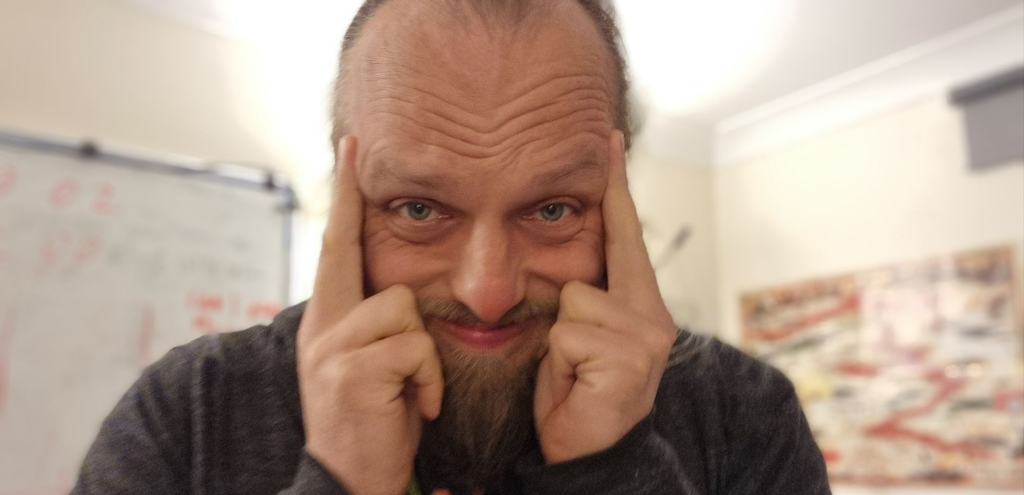 Full image of Dan, touching his temples, a pained look on his face.