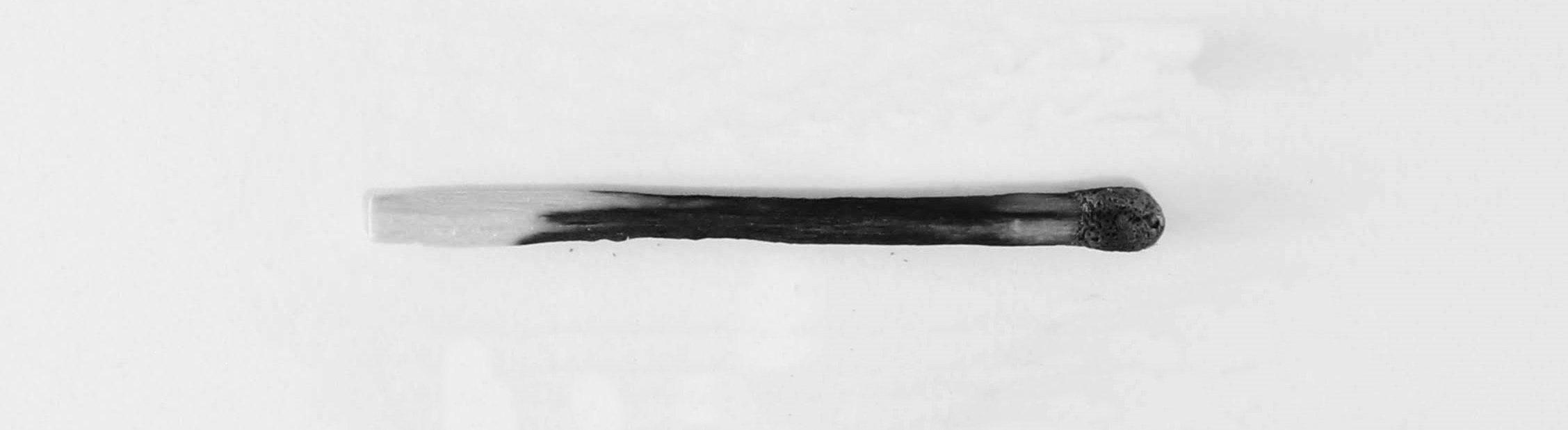 Full image of A matchstick, burned almost to the end.