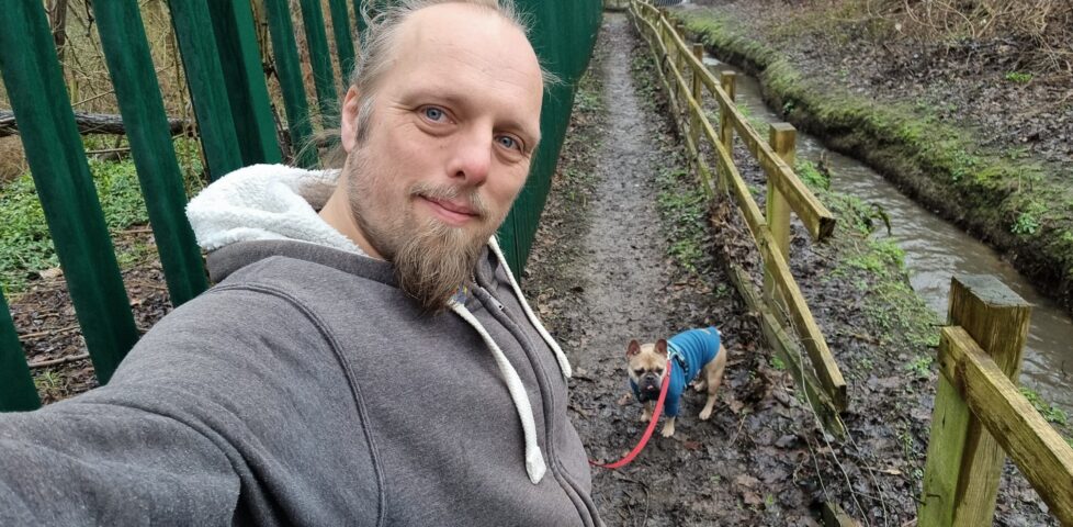 Dan with his dog on a muddy footpath.