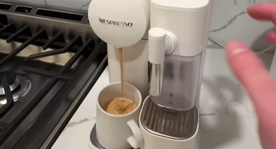 Framegrab from video showing a Nespresso machine making coffee, with the subtitle 'six shots of this caffeinated brown tea'.