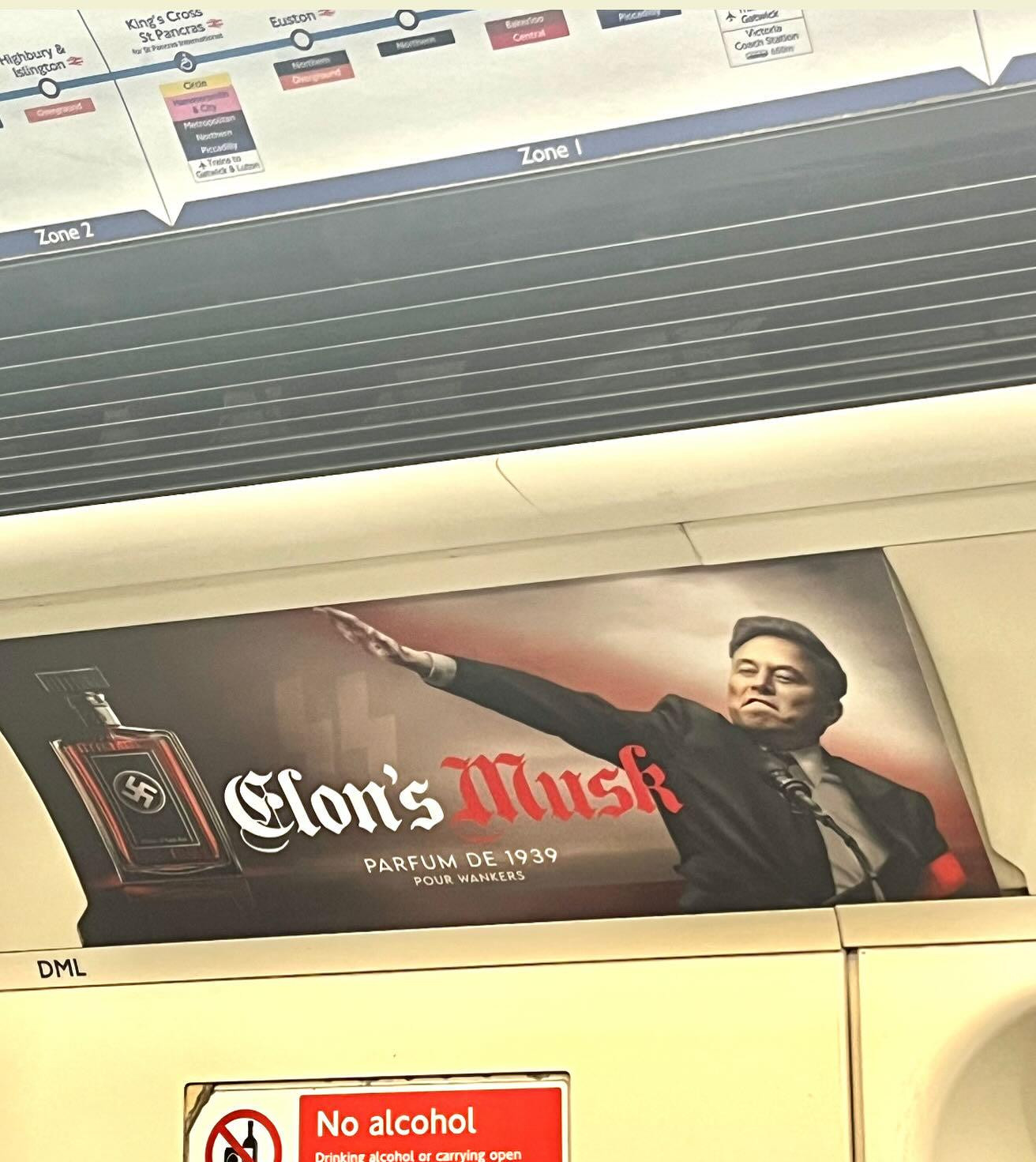 Full image of Photo of a parody advertisement on a London Underground train, showing Elon Musk doing a Nazi salute. The fake ad is for 'Elon's Musk', 'parfum de 1939'.