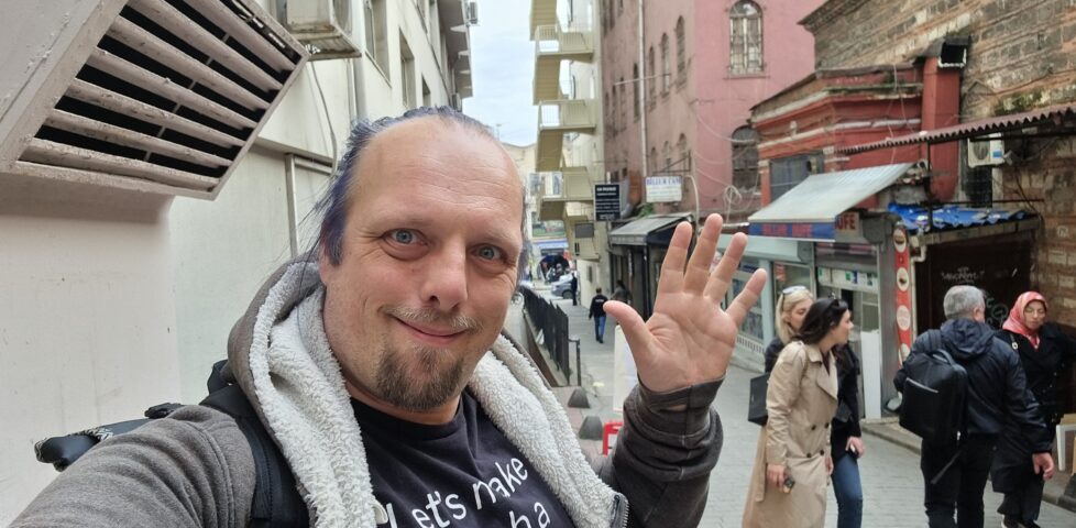 Dan waves from a narrow but busy Istanbul city street.