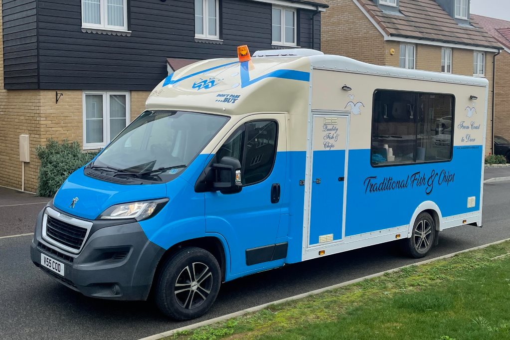 Full image of 'Howe & Co' Fish & Chip van, painted in white and blue and parked in a residential street.