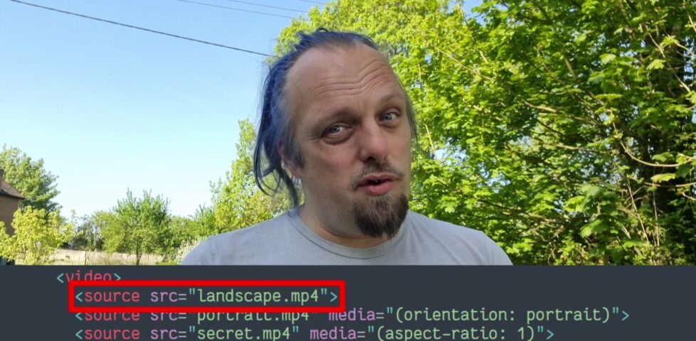Outdoors, under blue skies and trees, Dan tosses his blue ponytail as he talks about a code snippet superimposed beneath him, showing a HTML video element with the first source (landscape.mp4) selected.