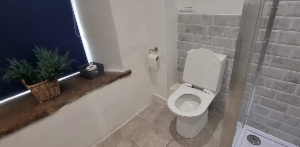 A toilet in a tiled bathroom.