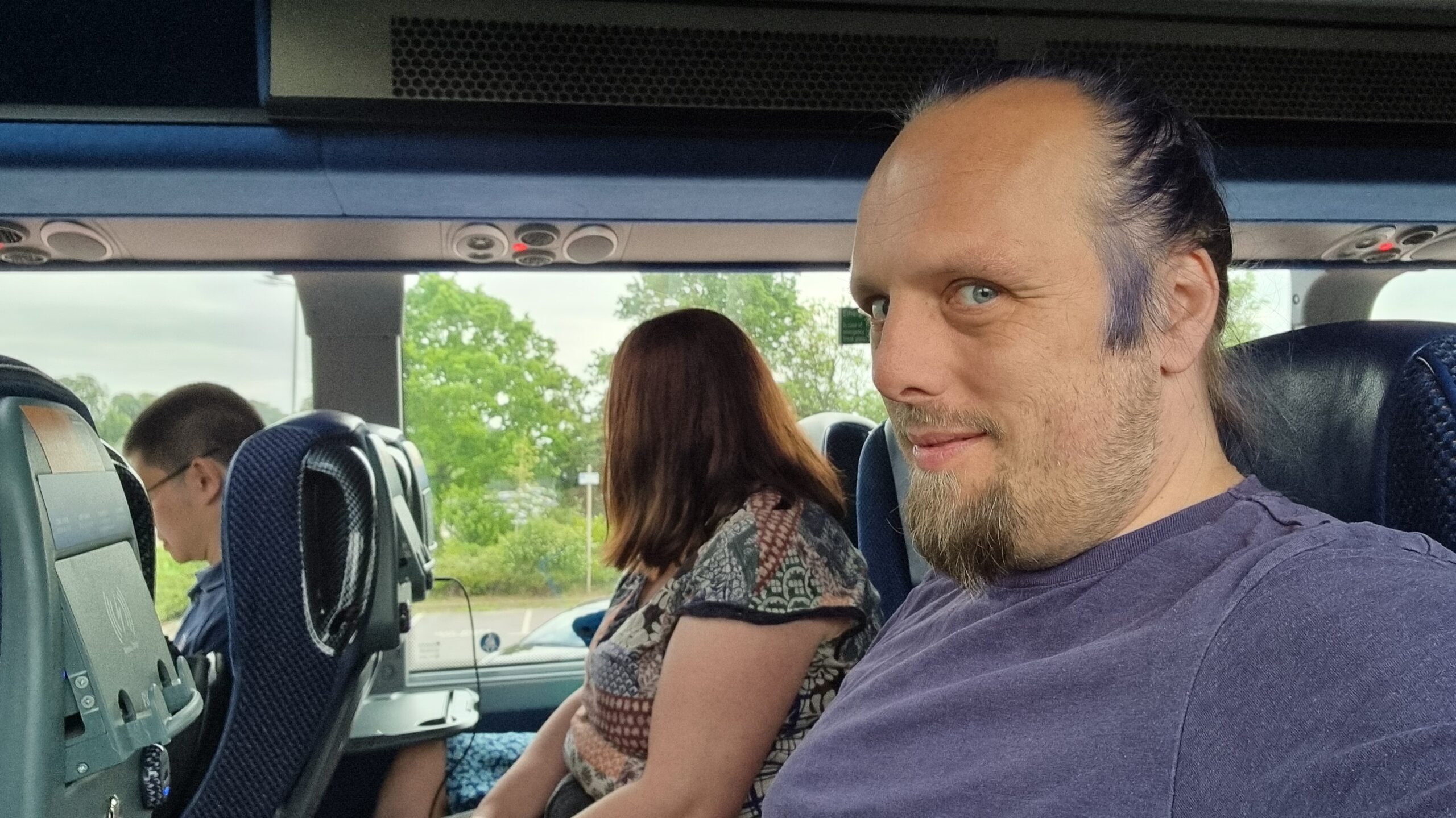 Full image of Dan, sitting on a bus.