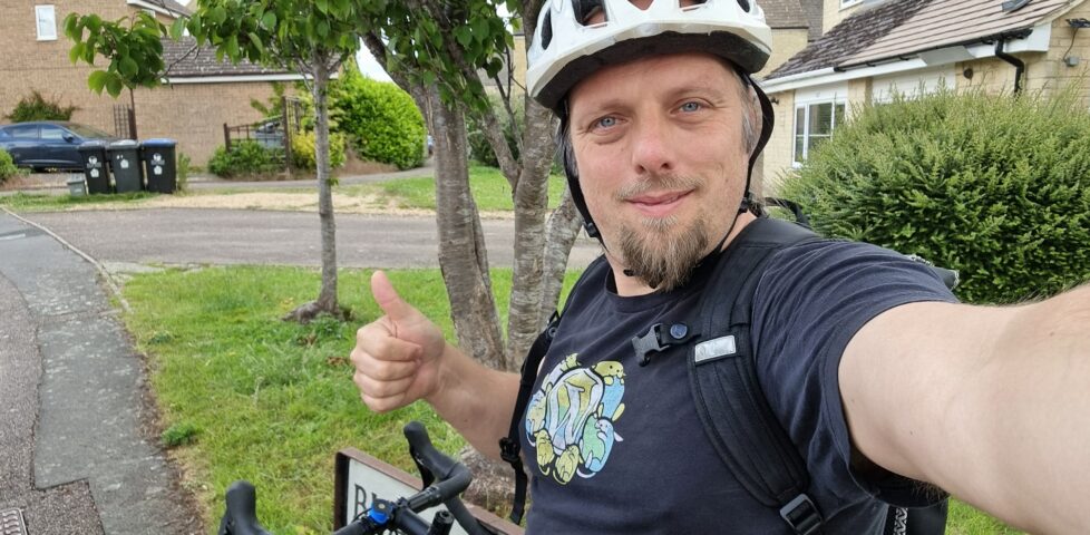 Dan, with his bike, throws a thumbs-up sign.