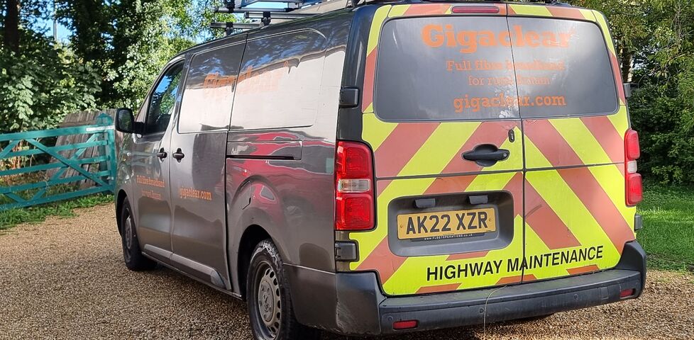 A Gigaclear van sits parked on a gravel driveway.