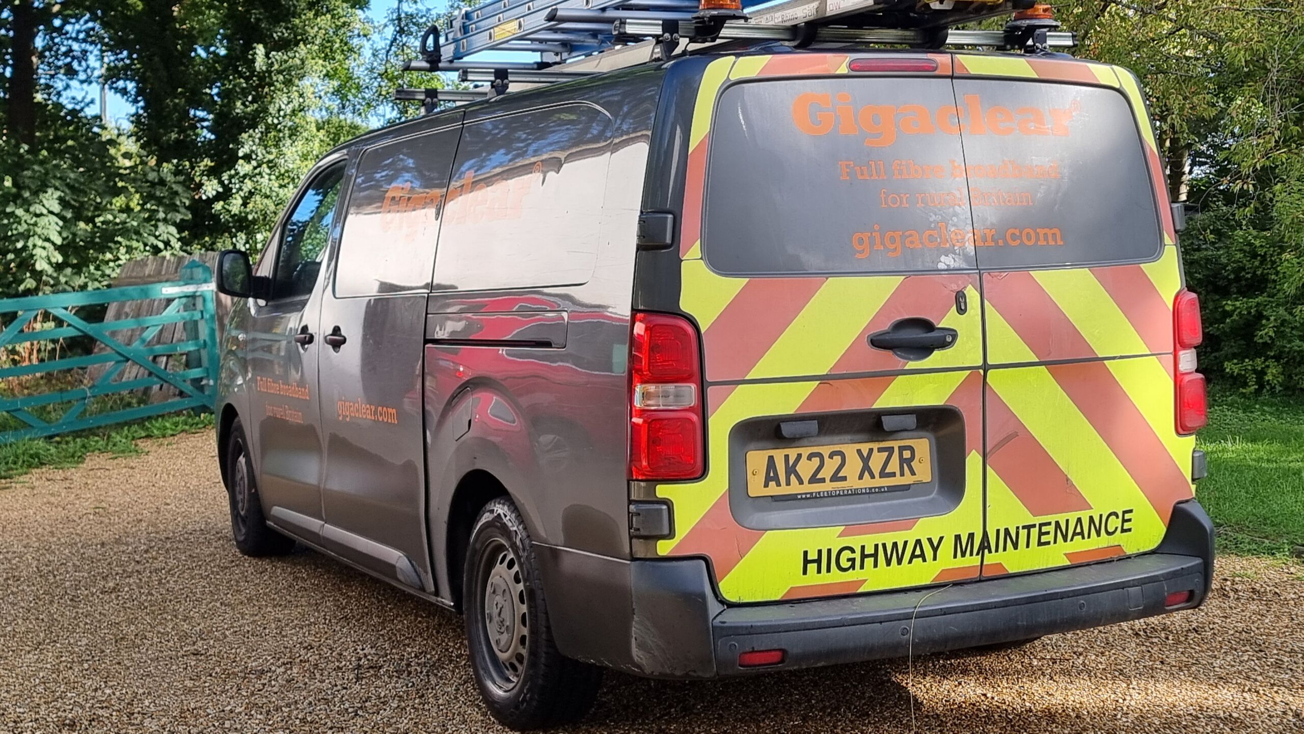 Full image of A Gigaclear van sits parked on a gravel driveway.