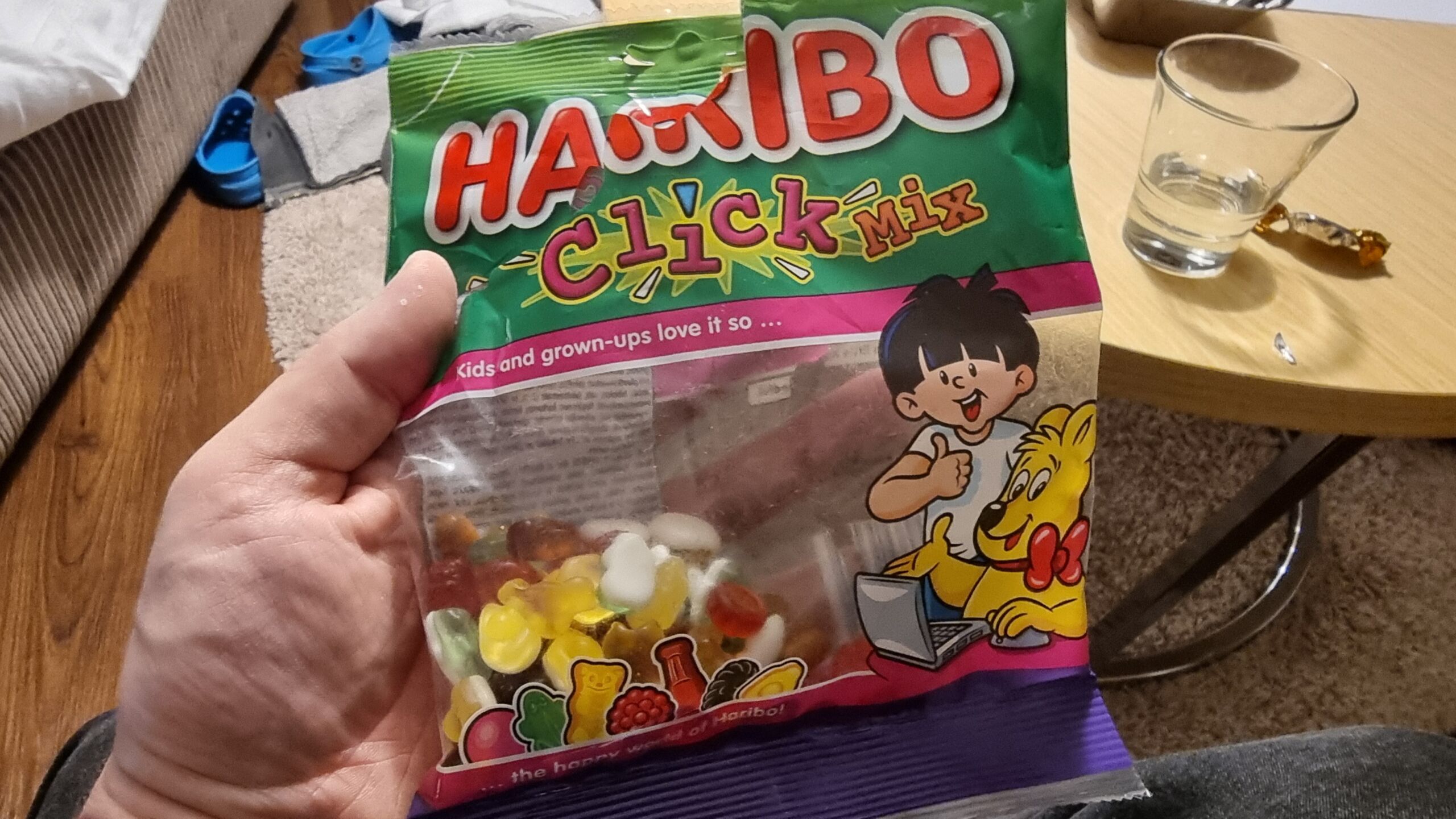 Full image of A bag of Haribo ClickMix, opened, held on a white hand.