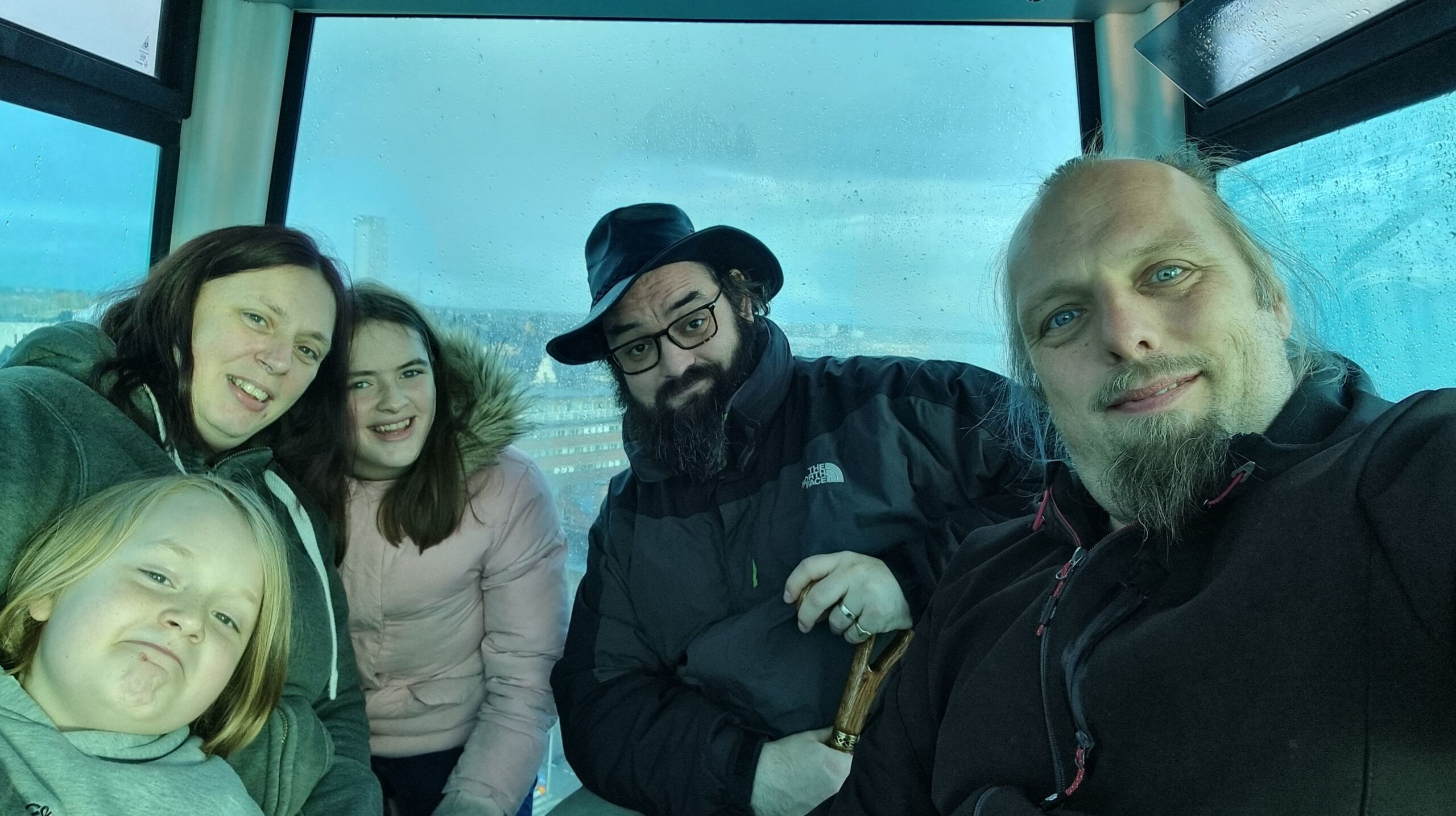 Full image of Dan, Ruth and JTA sit with their two children in the cabin of a ferris wheel.