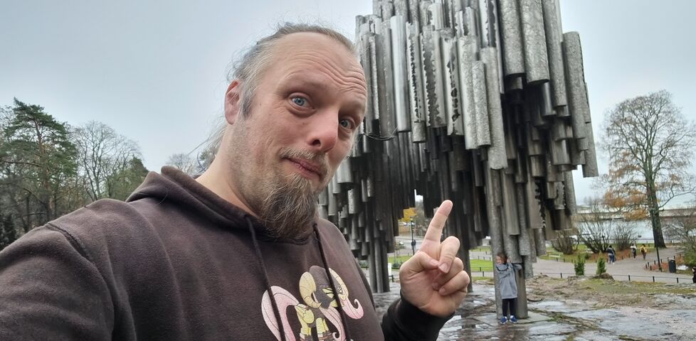 Dan points to an organic, tree-like sculpture formed from dozens of upright pipes.