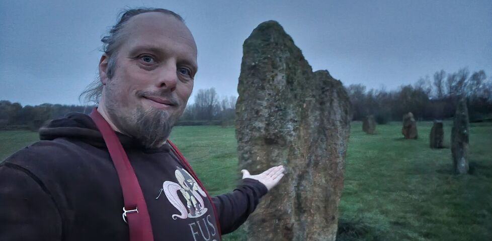 Dan in front of some standing stones at dusk.