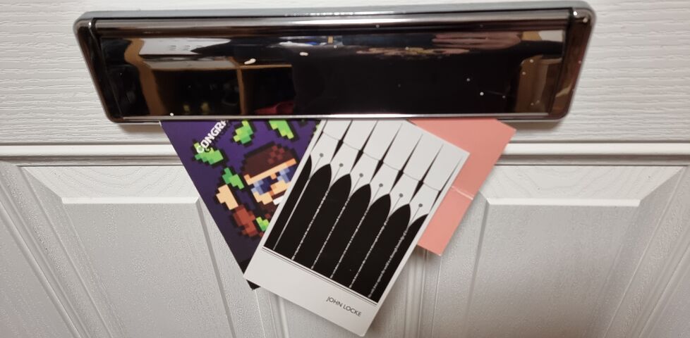 Three postcards coming through a residential letterbox.