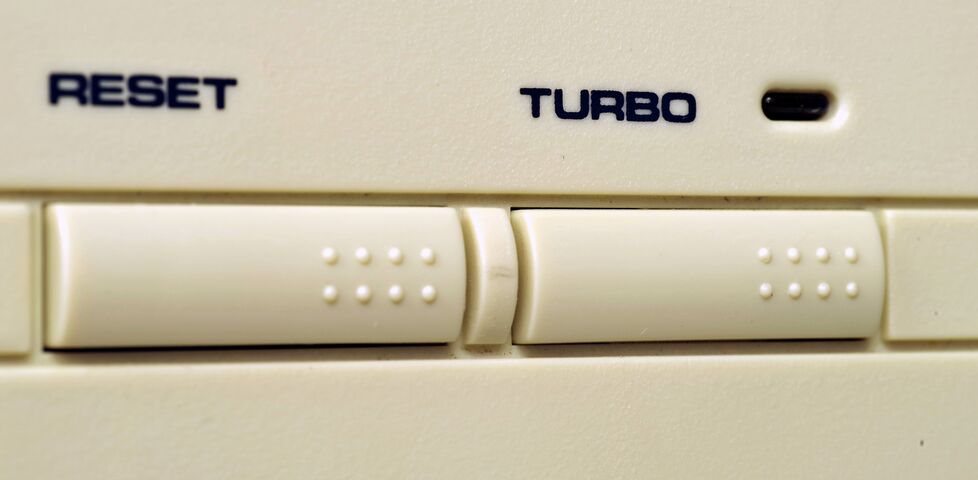Close-up photo of a computer with reset and turbo buttons.