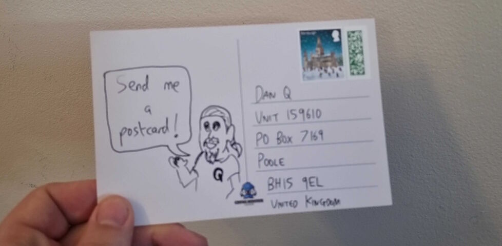 A stamped postcard addressed to Dan Q via his PO Box, showing a (badly) hand-drawn picture of Dan saying 'Send me a postcard!'