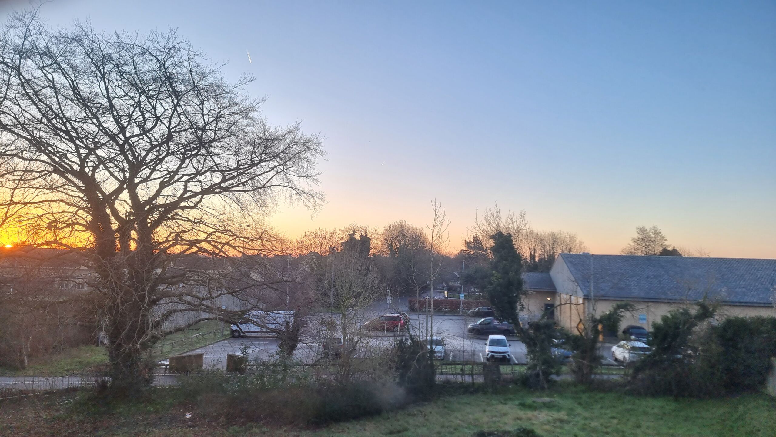 Full image of Sun rising through hazy but clear skies.