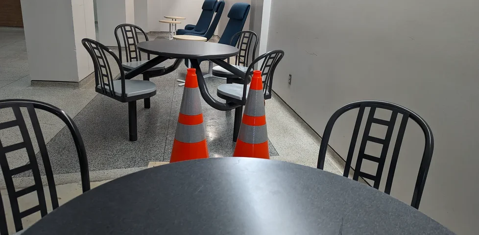 Two cones sitting at a table in a university cafe