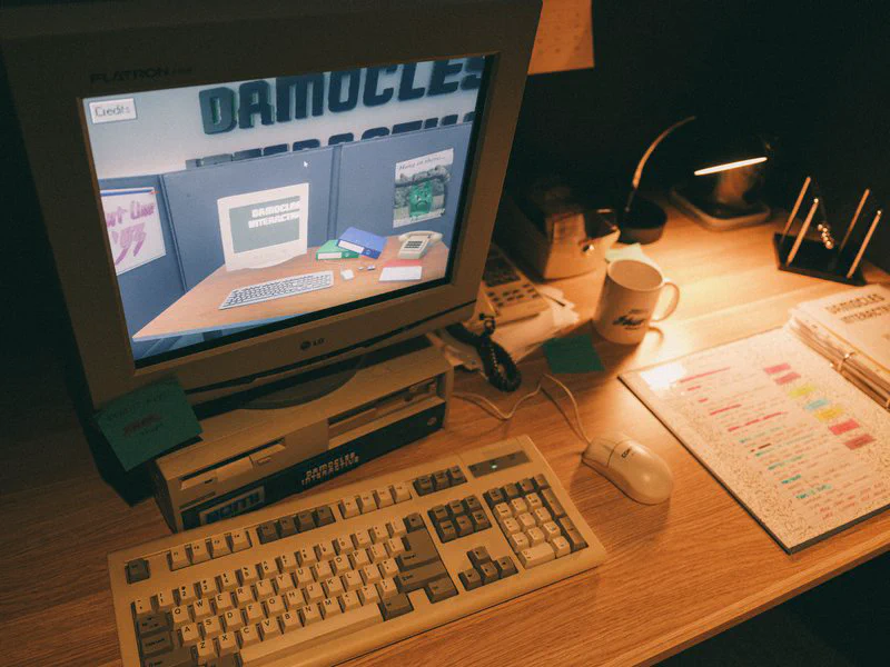 Full image of A retro computer and compendium, showing a digital representation of the same on its screen.