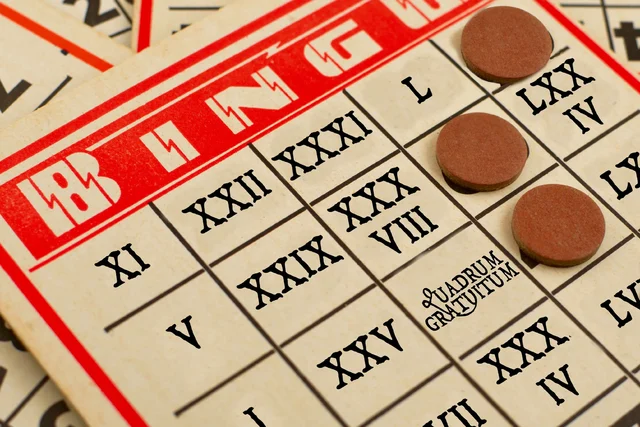 An American-style bingo card with Roman numerals in place of the numbers and 'quadrum gratuitum' in place of the free space. Based on an original photo by Oeil De Vautour / Edwin Torres, used under a Creative Commons Attribution 2.0 Generic license.
