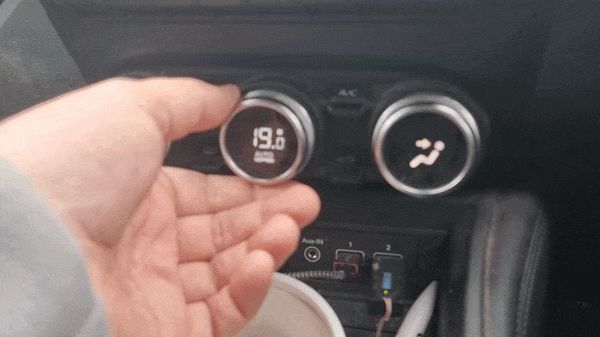 A white hand turns the thermostat knob in a car from 19℃ to 20℃ in 0.5℃ increments; the untouched nearby fan direction control seems to change of its own accord. Initially blowing towards the user's face it switches on 'towards feet' at 19.5℃ and switches off 'towards face' at 20℃, and reverses the process when the temperature is turned down again.