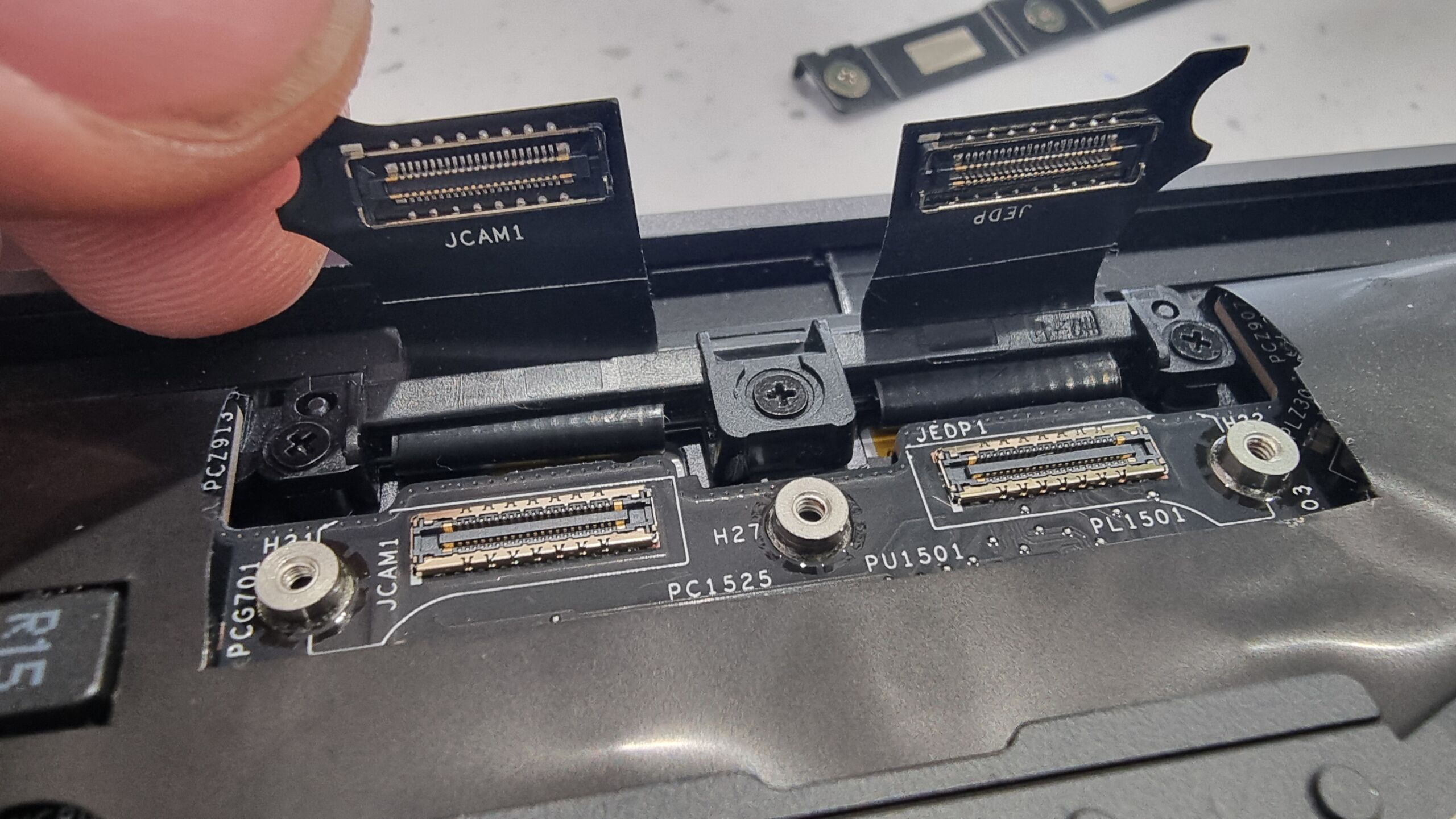 Full image of Close-up of tiny sockets on ribbon cables within the housing of a laptop.