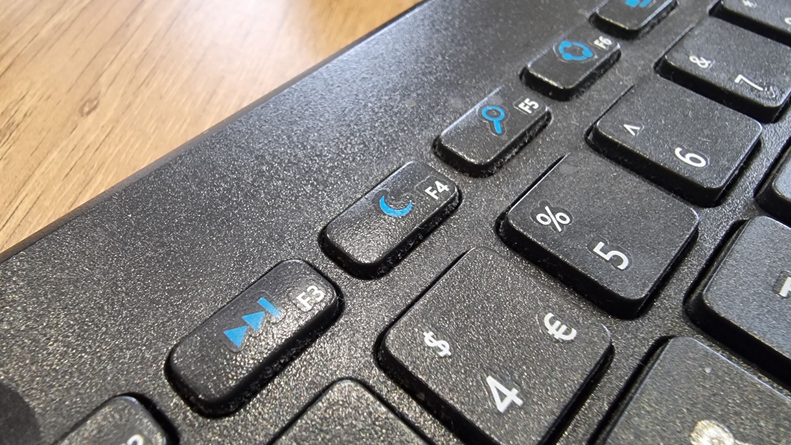 Full image of Close-up of the F4 key, showing a 'moon' icon. Of the other visible function keys, F3 shows 'fast forward', F5 shows 'hourglass', F6 shows what appears to be an illustration of a supercollider spinning up, and so on.
