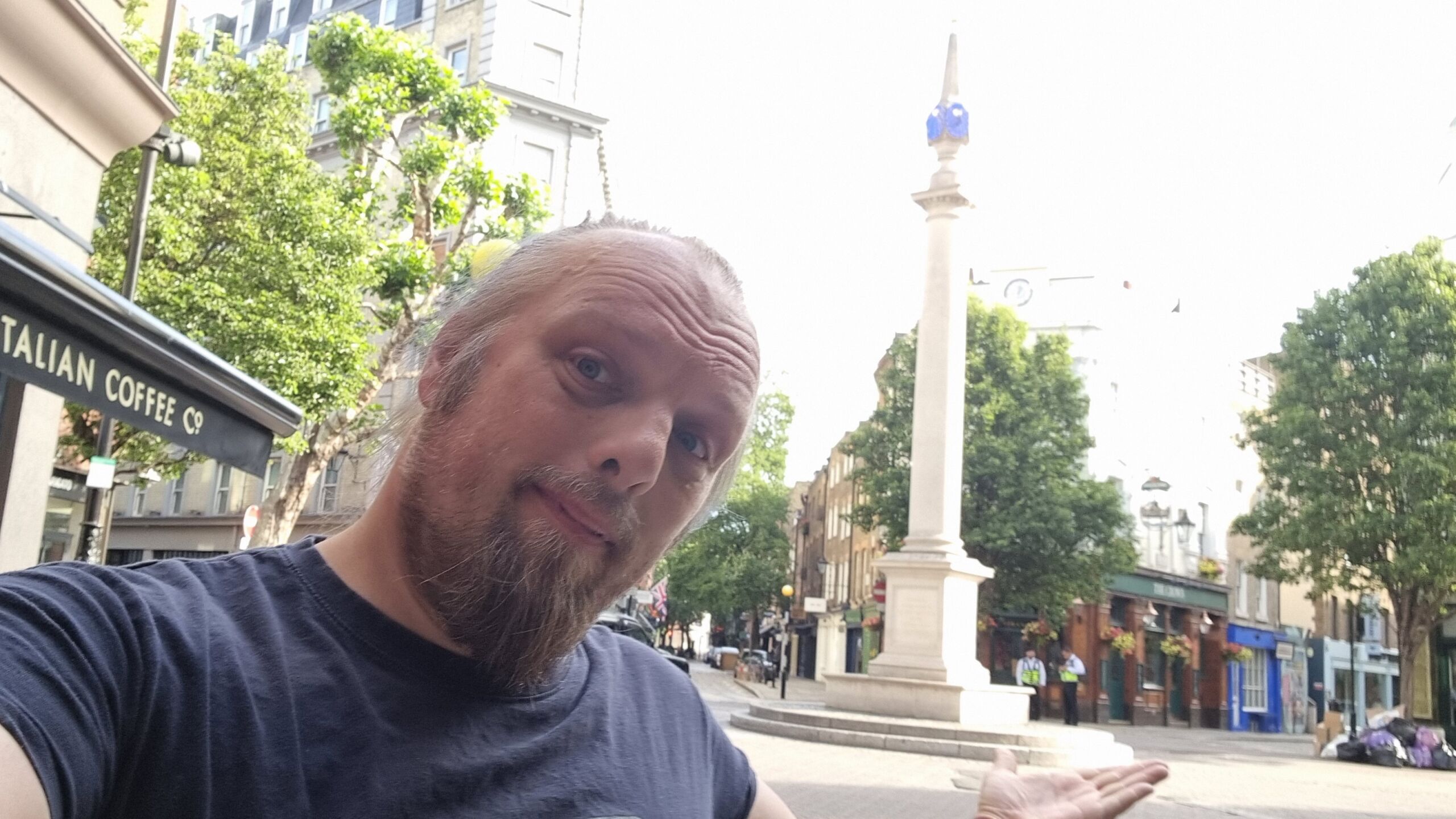 Full image of Dan in front of a tall pillar in the morning sun.