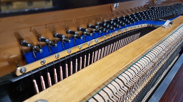 The pristine inside of an upright piano.