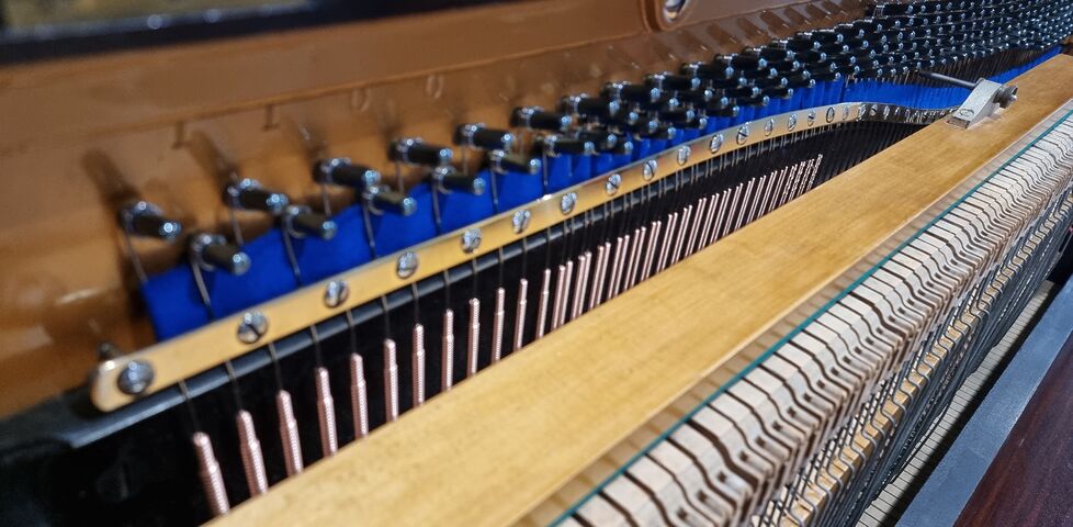 The pristine inside of an upright piano.