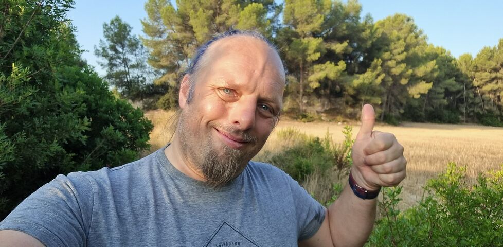Dan throws a 'thumbs up' to the camera.